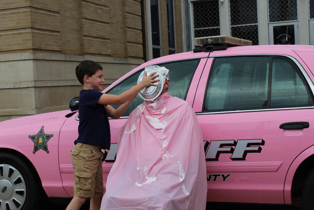 Wyatt Kervin putting pie in Sheriff Sedinger's face