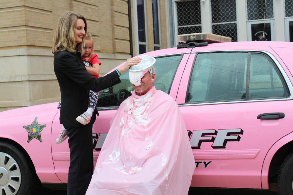 Judge Joy Booth putting a pie in Sheriff Sedinger's face