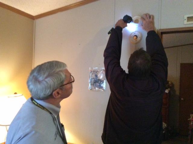 Fire Marshall Chuck Gorey installing smoke detector